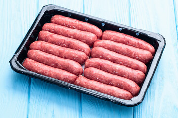Raw beef sausages with rosemary and tomatoes photography . Top view