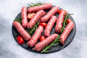 Raw beef sausages with rosemary and tomatoes photography . Top view