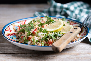 Tabbouleh salad with couscous on wooden table