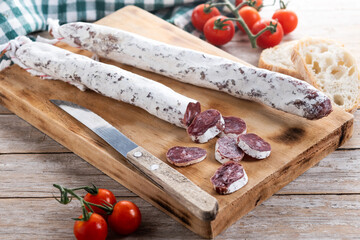 Fuet.Dry cured fuet sausage on wooden table