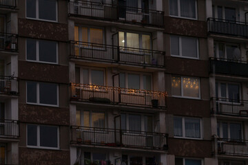 Fototapeta premium A tall building that features numerous windows and balconies, beautifully illuminated at night, creating a stunning architectural view