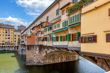 Captivating view of Ponte Vecchio bridge with vibrant houses over the Arno River in Florence during daylight
