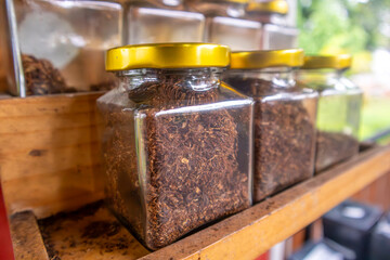 Dried smoking tobacco in a glass jar, cigarette ingredient material