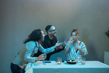 Friends enjoying drinks and laughing together at dinner table