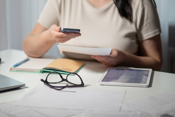 Woman paying bills online using smartphone at home. Bill paying concept. Digital payment using internet banking and qr code