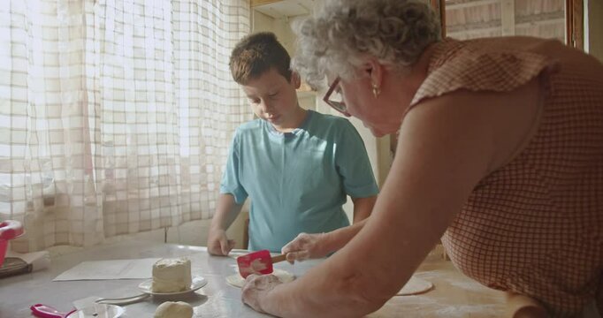 A grandmother and her grandson share a special moment making pastries together, passing down family recipes and creating lasting memories in a cozy kitchen.