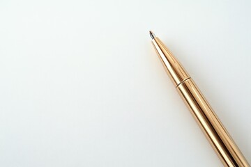 A gold-colored pen rests on a white background, ready to write.