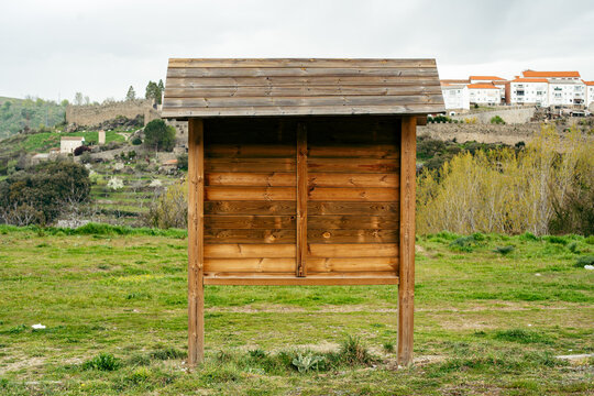 Tabl&oacute;n de anuncios de madera en una zona de recreo verde. 