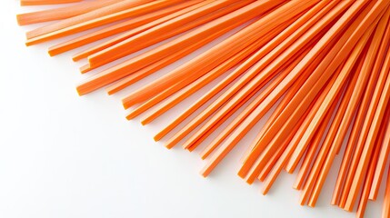 Carrot sticks arranged in a fan pattern on a bright white backdrop, emphasizing their uniformity.
