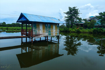 Fototapeta premium View of a wooden Gezebo above the lake in the morning
