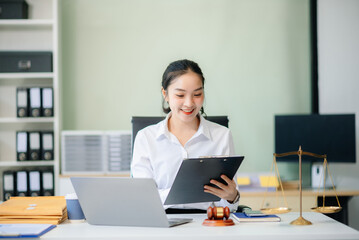 young female lawyer handling legal documents at her office desk