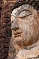 Obraz premium Wat Phra Si Rattana Mahathat Chaliang Khmer Ruin with a walking Buddha in classical Sukhothai style and apsara on front mini-prang