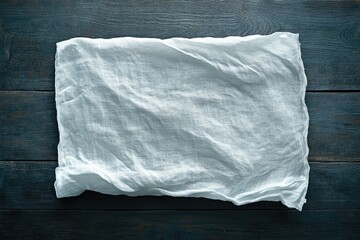 Obraz premium White linen fabric on dark wooden background, simple and elegant texture.