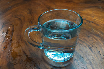Water in a glass on a wooden table, suitable for the background