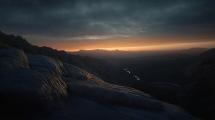 A breathtaking sunset over a rugged mountain range, with a sliver of golden light illuminating the horizon.