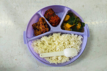 Rice side dishes in a blue Tupperware lunch box on the table