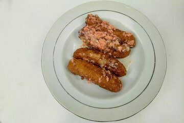 Banana cake is served on a white plate on a white table