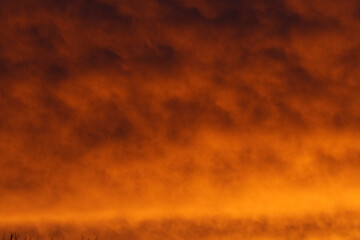 Fiery orange-red sunset clouds fill the sky.  Dramatic, atmospheric.