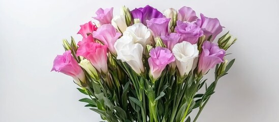 Fototapeta premium Bouquet of vibrant eustoma flowers in pink and lilac with white accents on a light background offering ample copy space for text.
