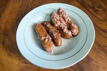 Banana cake is served on a white plate on a white table