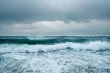 Fototapeta premium Dark clouds loom over a stormy sea, where fierce waves rise and crash, illustrating the intensity of the weather. Stormy ocean waves under a graying sky .