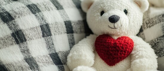 Plush toy polar bear with a red heart on a white patterned plaid background creating a cozy and inviting atmosphere for soft toy lovers