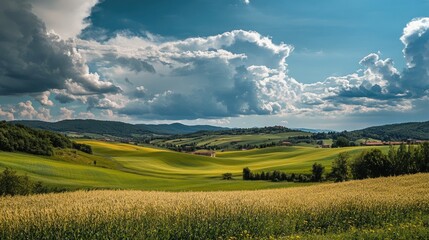 Obraz premium Lush green hills under a dramatic cloudy sky with sunlight breaking through the clouds on a vibrant day