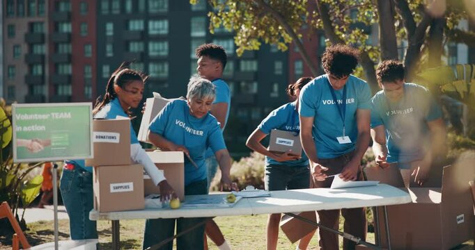 Team, volunteering or outdoor with boxes for charity, donation drive or community service. NGO people, package or checklist in city for social responsibility, distribution or food supply for poverty