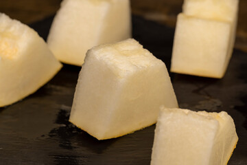 pieces of sliced ripe and sweet melon on a black surface