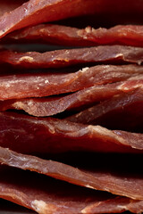 dried dried meat from meat tenderloin with spices and salt on black slate