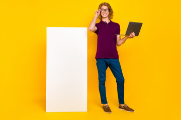 Full length photo of hr ginger guy stand hold laptop wear eyewear casual cloth isolated on yellow background