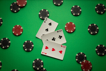 Three threes or a combination of playing cards three of a kind, set. Winning chips and cards for playing poker are scattered chaotically on a green table
