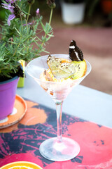 A sophisticated martini glass elegantly adorned with a butterfly on top of it