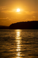 Naklejka premium orange sky during sunset on the lake