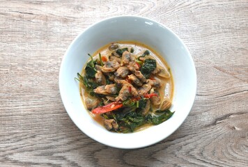 spicy boiled clam with basil in curry and coconut milk soup on bowl