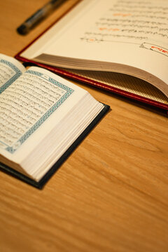 Open Arabic Books and Quran on Wooden Table with Elegant Script and Negative Space