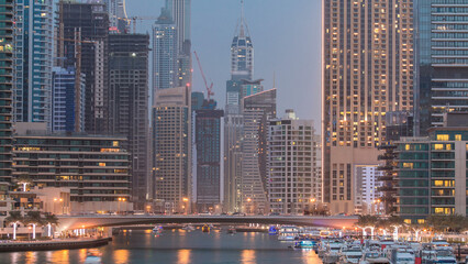 Evening Dubai marina city centre with floating vessels day to night timelapse