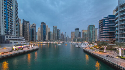 Fototapeta premium Evening Dubai marina city center with floating vessels day to night timelapse