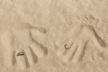 Brautpaar hinterlässt Händeabdruck im Strandsand auf einer Strandhochzeit