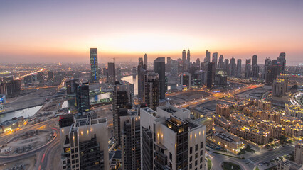 Obraz premium Aerial view of a big modern city day to night timelapse. Business bay, Dubai, United Arab Emirates.