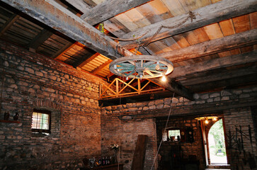 Rustic Interior with Stone Walls, Wooden Beams, and a Wheel Chandelier