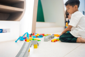 Kindergaretn asian boy enjoying play building colorful toy block in school