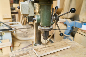 Industrial drill press in action at a bustling lumberyard