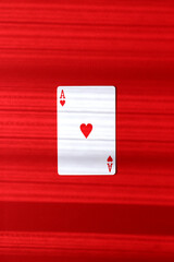 赤い背景に置かれたハートのエース（縦画像）