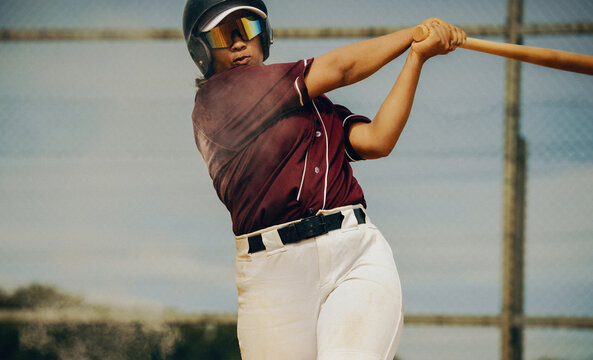 Female professional baseball batter hitting the ball during an intense game