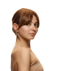 Side view portrait of attractive young woman in beige top, with spotless, clear, spotless skin, posing against white studio background. Concept of natural beauty, skin care, cosmetics and cosmetology