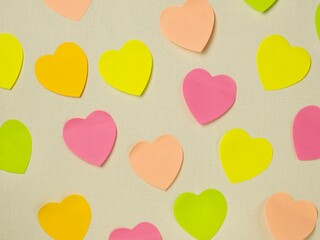 Paper hearts with copy space are glued to the white wall