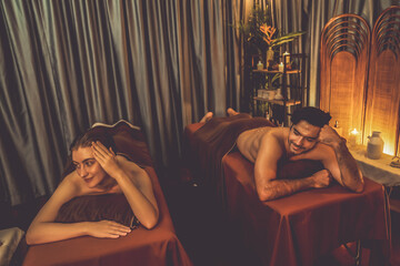 Obraz premium Couple customer having exfoliation treatment in luxury spa salon with warmth candle light ambient. Salt scrub beauty treatment in Health spa body scrub. Quiescent