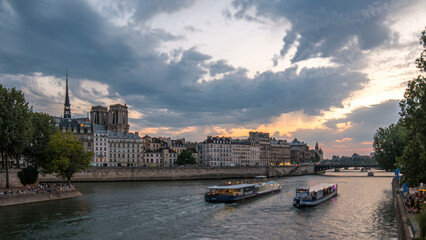 Obraz premium Le Pont D'Arcole bridge after sunset with people and boats day to night timelapse, Paris, France, Europe