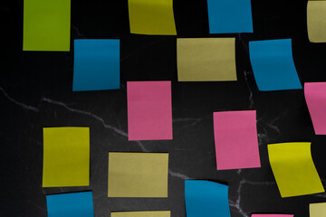 Colorful sticky notes arranged on black surface for creative idea organization